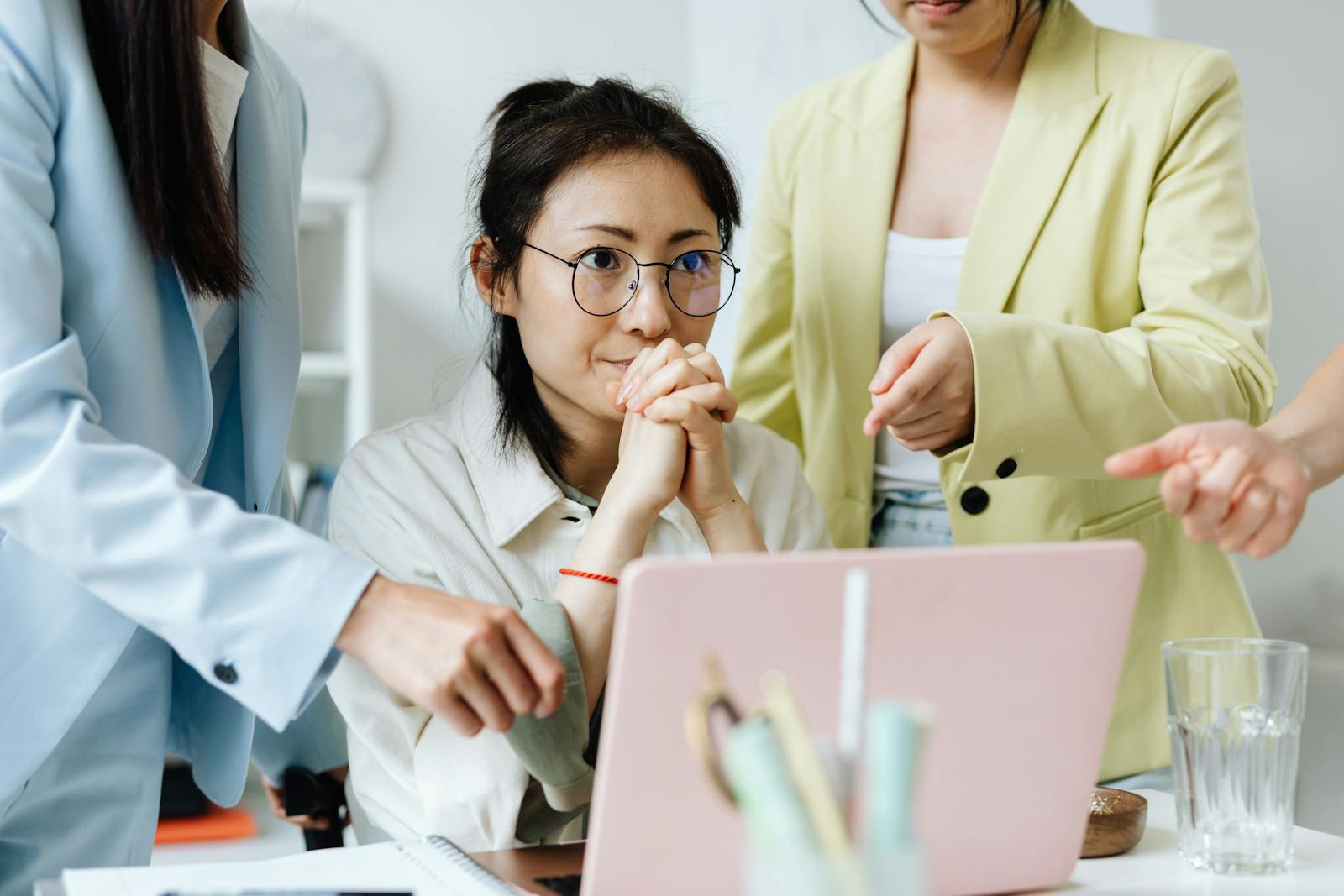 Three businesswomen collaborating on a project in a modern office setting.