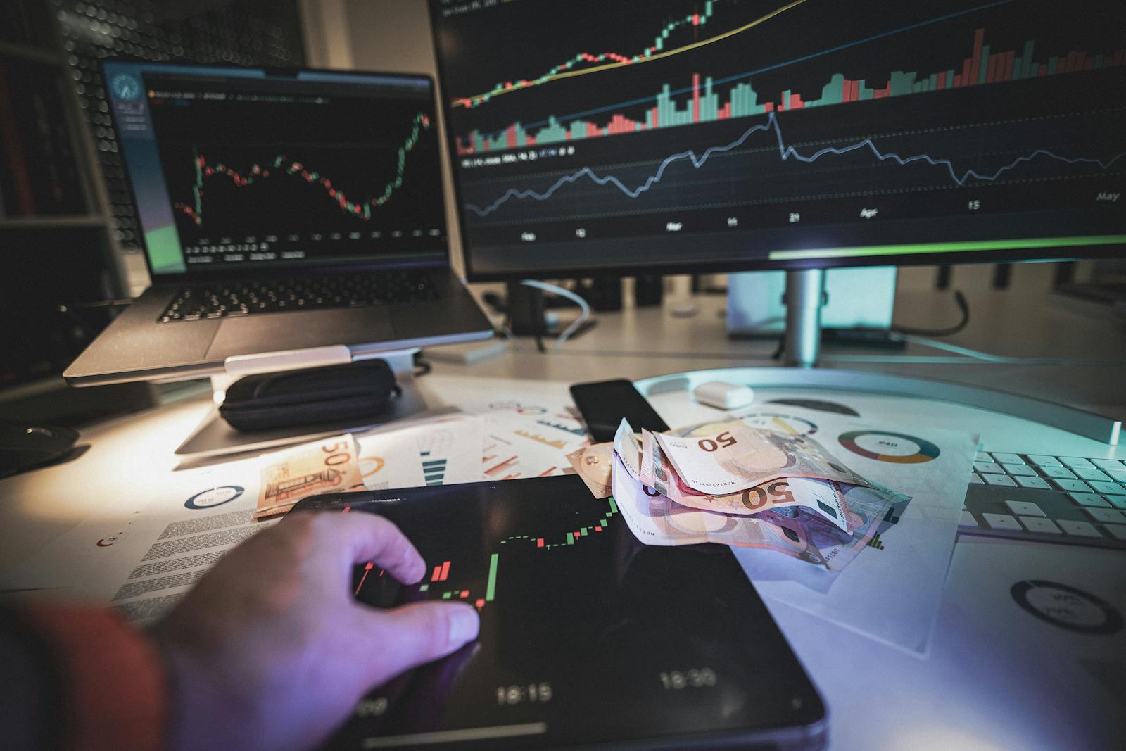 A modern trading desk with screens showing market charts and euro notes, capturing a trading atmosphere.