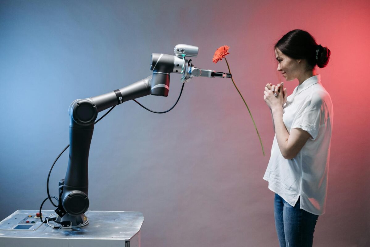 A robotic arm offers a flower to a woman in a display of technology and human connection.