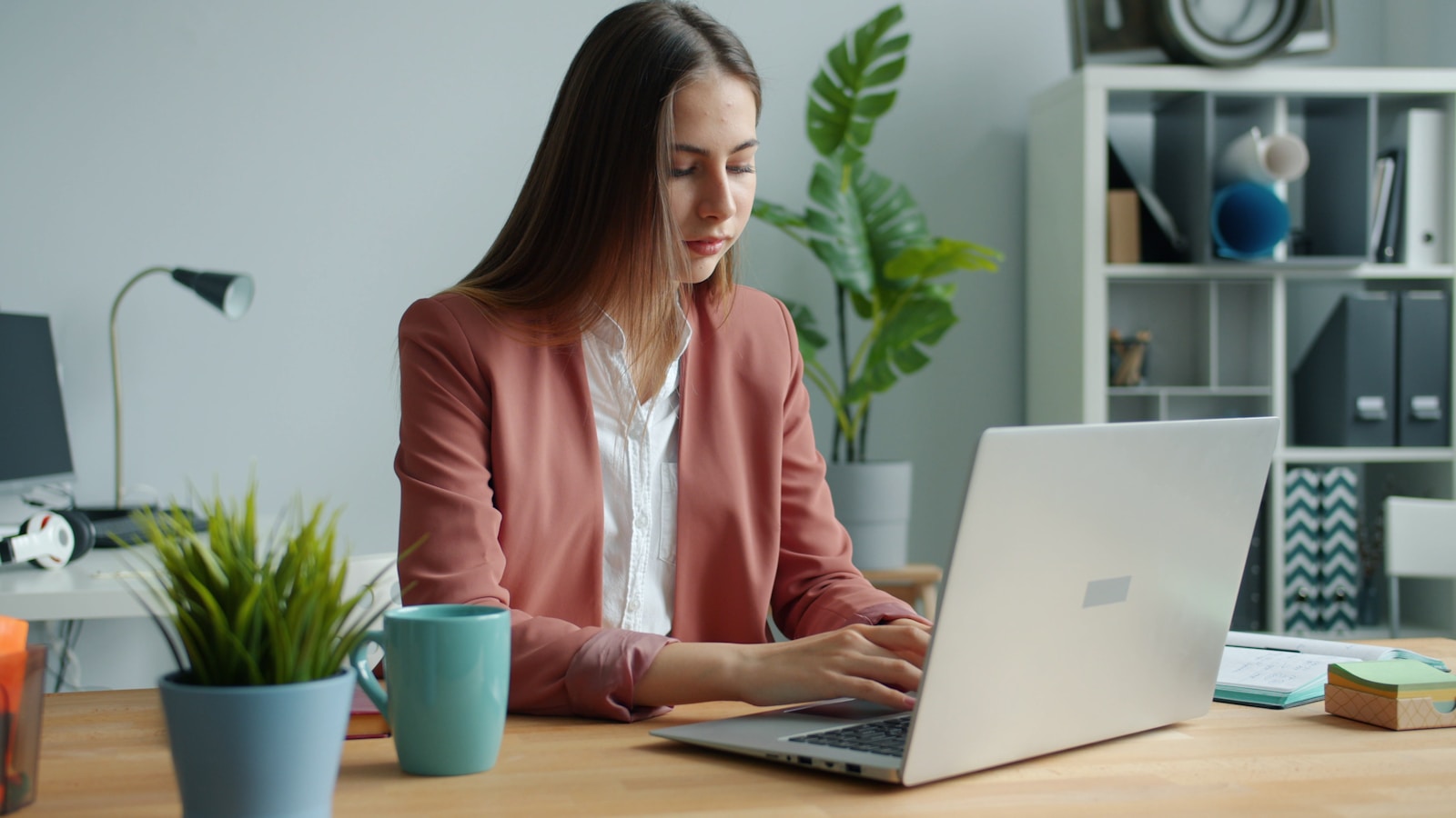 Professional working on a laptop at a desk, representing CPQ for automotive sales configuration and quoting.