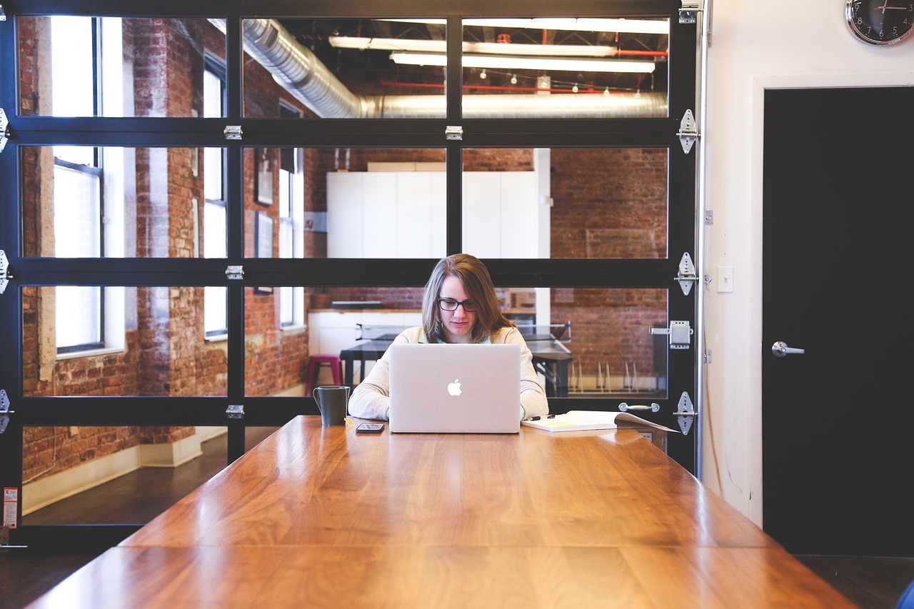 Professional working on a laptop at a conference table in a modern office, representing SAP CPQ Approval processes.