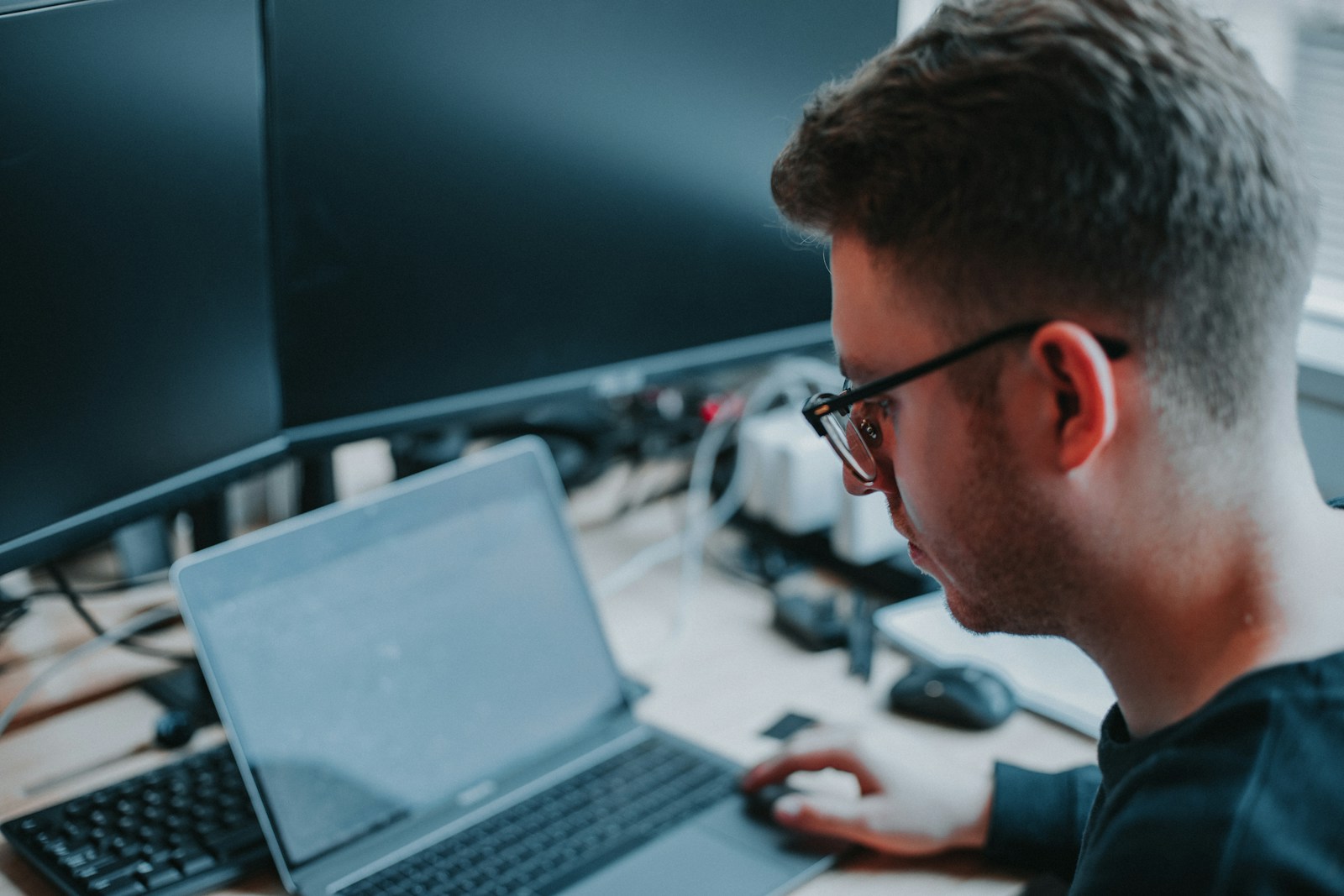 Young IT professional working on a laptop during training for IT support teams in a modern office.