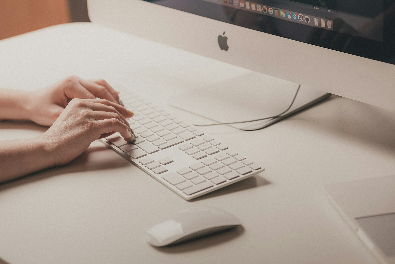 Close-up of hands typing on a keyboard in a modern workspace, representing SAP CPQ sales processes.