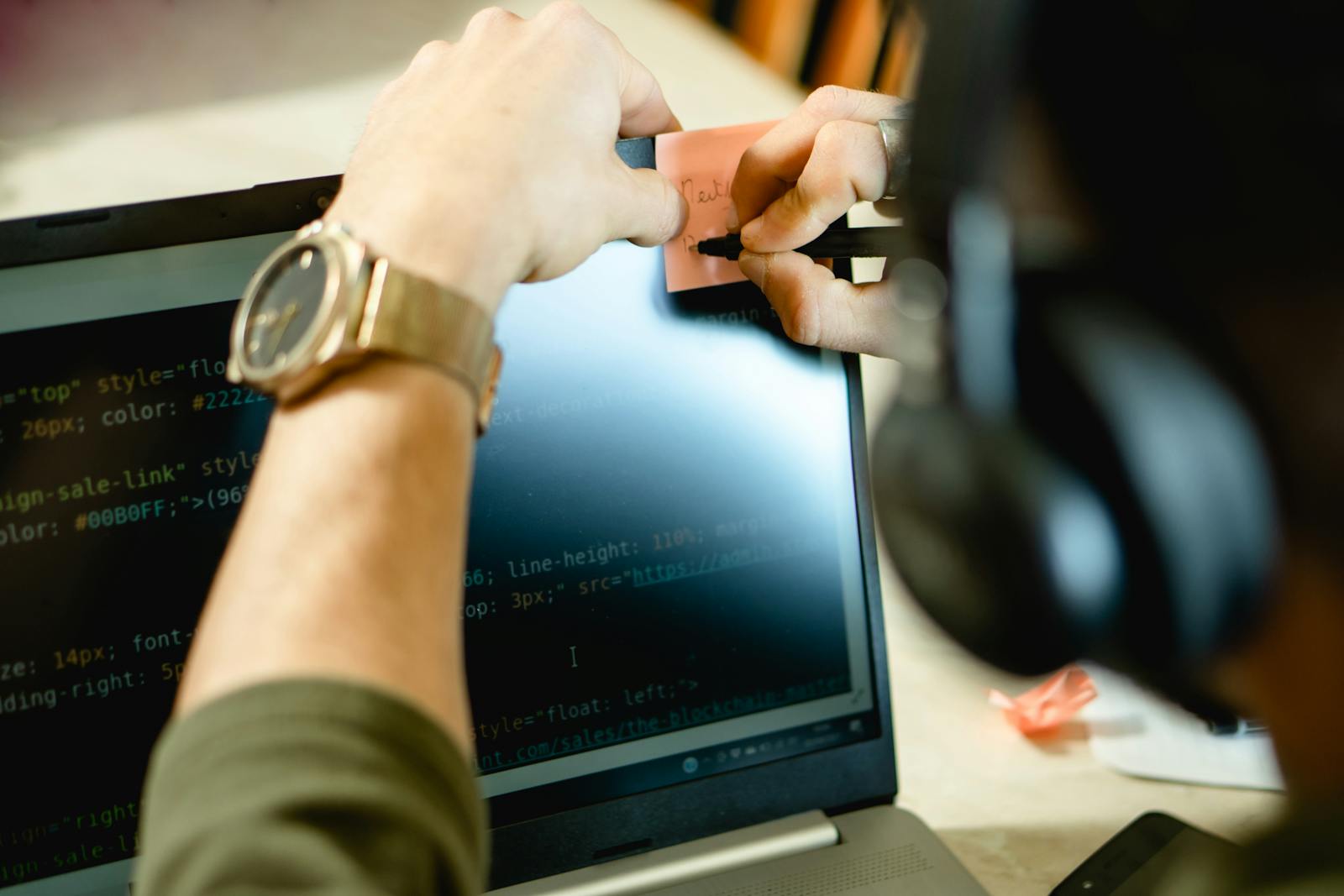 Professional reviewing code and notes on a laptop screen, illustrating SAP CPQ Training for Sale operations and hands-on learning for sales process optimization.