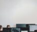 man in black jacket sitting beside black flat screen computer monitor