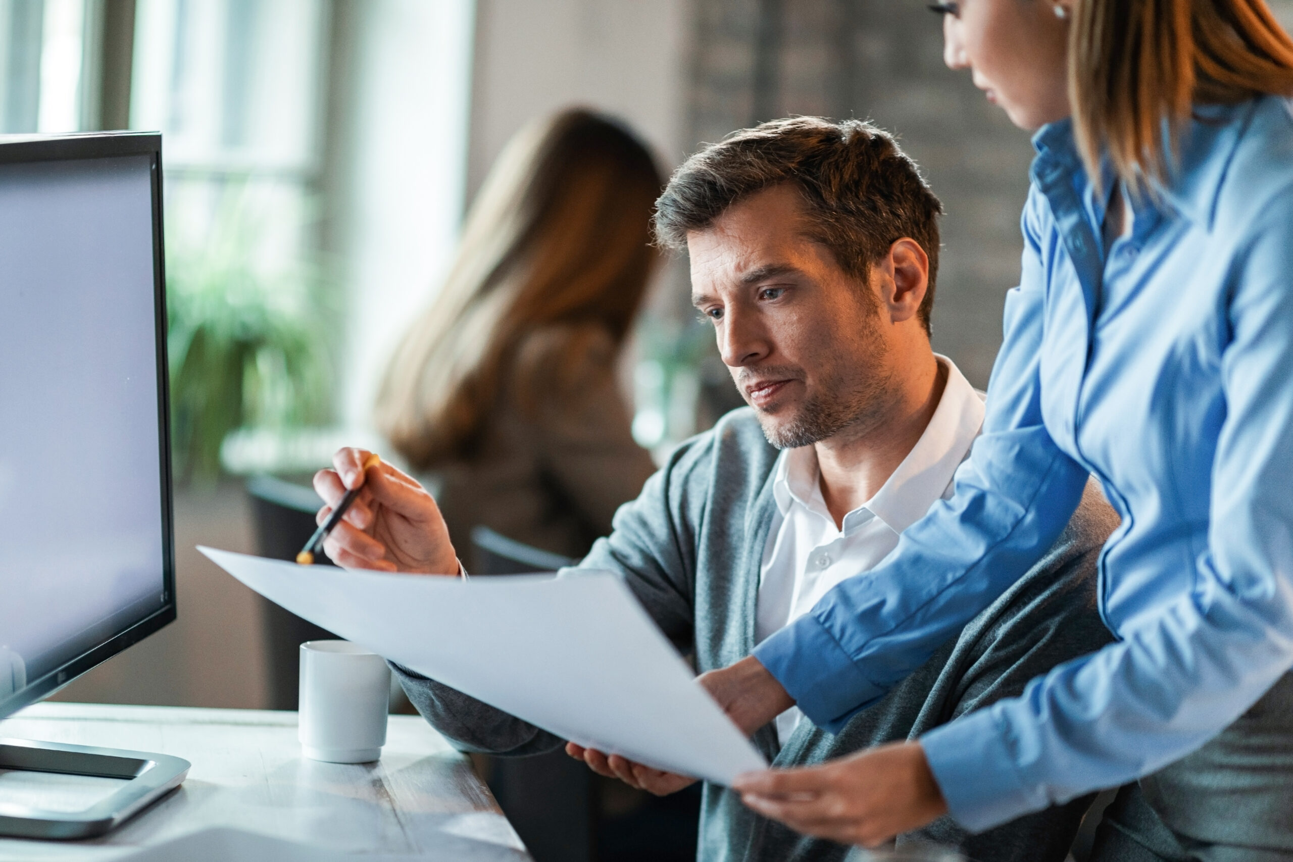 Two managers reviewing documents and project scope for an SAP CPQ implementation