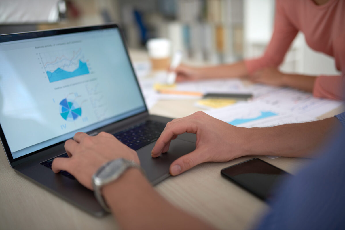 Laptop screen with charts while a team reviews the SAP CPQ 2609 release