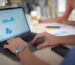 Laptop screen with charts while a team reviews the SAP CPQ 2609 release