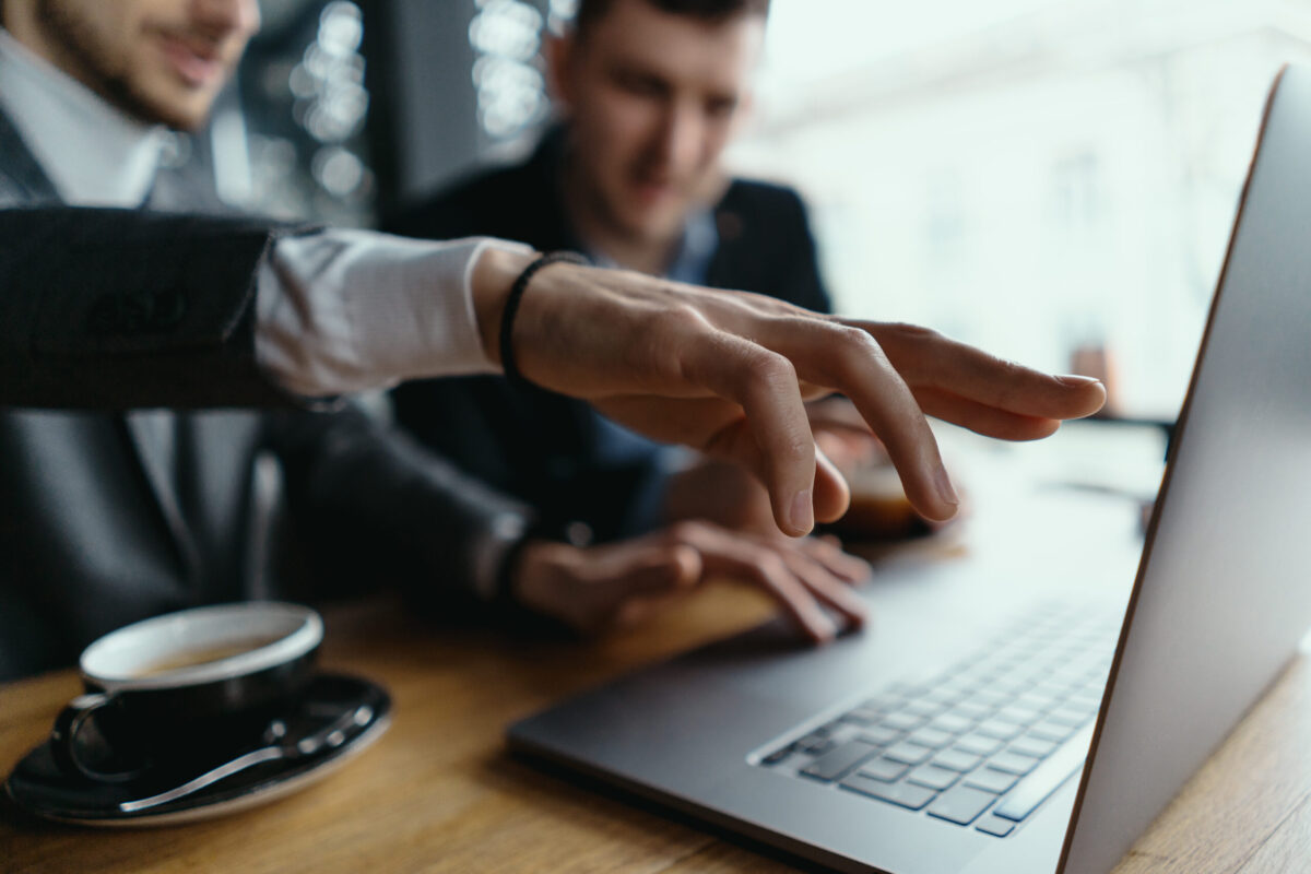 Two colleagues reviewing SAP CPQ 2609 fixes on a laptop